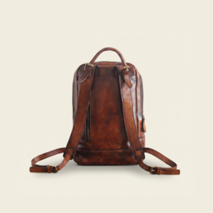 Back of the top-grain leather travel backpack, studio photograph on cream background