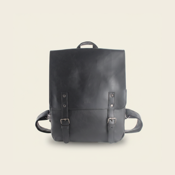 Black vegan PU leather travel laptop backpack, studio photograph on cream background