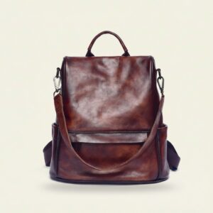 The Nomad convertible leather backpack in vintage coffee on cream background