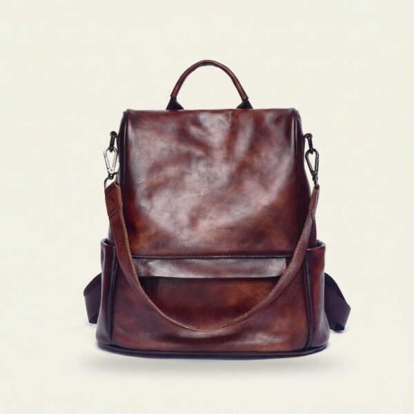 The Nomad convertible leather backpack in vintage coffee on cream background