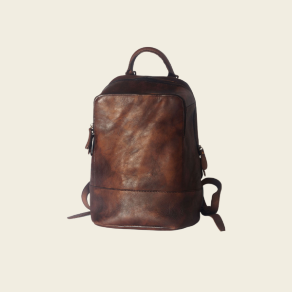 Coffee top-grain leather travel backpack on cream studio background